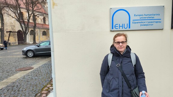 Dr hab. Anna Sakowicz w Wilnie przy tabliczce Europejskiego Uniwersytetu Humanistycznego